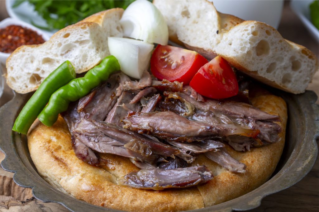 Tabakta Soğan ve Tırnak Pide ile Servis Edilmiş Fırın Kebap